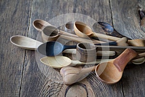 Side view lot of wooden spoons made of precious wood on wooden table, eco-friendly concept of cutlery, handmade tableware