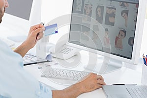 Side view of a male photo editor working on computer