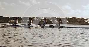 Side view of male rower team rowing on the lake