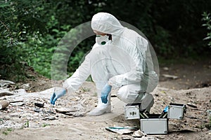 side view of male scientist in latex gloves taking sample of stone