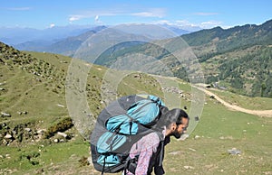 Side view of a male tourist carrying parachute backpack, walking in beautiful mountain of Himachal Pradesh