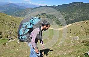 Side view of a male tourist carrying parachute backpack, walking in beautiful mountain of Himachal Pradesh