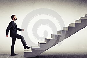 Side view of a man in a formal wear climbing concrete stairs