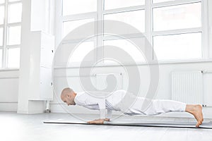 side view on man keeping balance on hands, doing yoga exercises