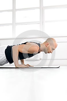 side view on man keeping balance on hands, doing yoga exercises