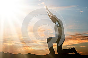 Man Kneeling And Praying At Sunset photo