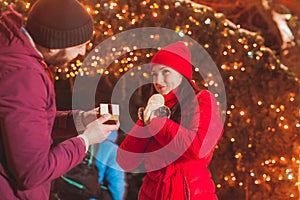 Side view of man making proposal of marriage on Christmas eve outdoors