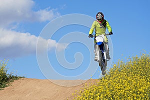 Side view of man performing stunt with motorcycle on motocross track