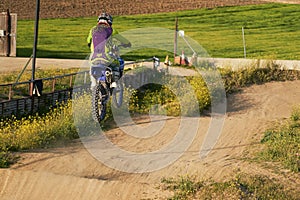 Side view of man performing stunt with motorcycle on motocross track