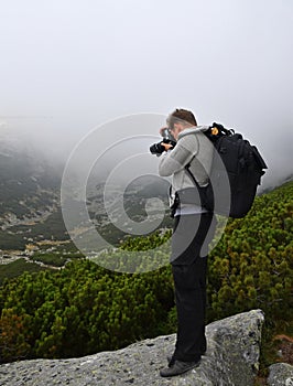 Side view of man photographer in foggy mountains
