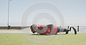 Side view man with prosthetic leg doing push ups