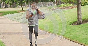 Side view man with prosthetic leg and using his phone while walking