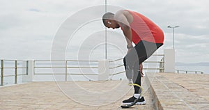 Side view man with prosthetic leg walking and sitting