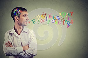 Side view man talking with alphabet letters in his head coming out of open mouth