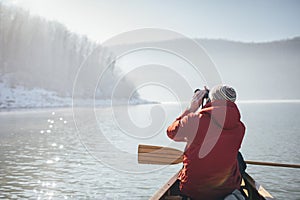 Rear view of man watching birds from the canoe