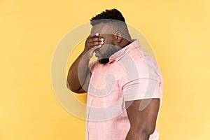 Side view of man closing eyes with hand, dont want to see that, ignoring problems.