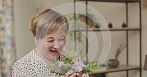 Side view of mans hand giving beautiful elderly woman bouquet . Cheerful retired lady getting flowers, smiling posing to