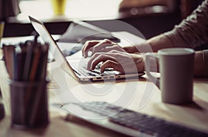 Side view on mans hands typing on computer.