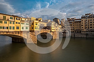 Side view of medieval stone bridge Ponte Vecchio over the Arno River in Florence, Tuscany, Italy.