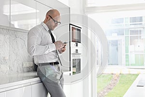 Side view of mid adult businessman using cell phone at home