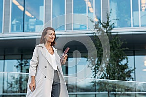 Side view of a middle-aged stylish attorney holding a folder