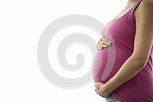 Side View Midsection Of Pregnant Woman With Hands Holding Tummy photo