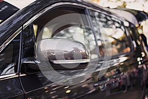 Side view mirror and side view of luxury car.