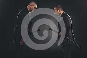 side view of modern samurai in suits bowing to each other