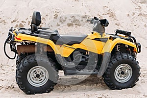 side view of modern yellow all-terrain vehicle standing in desert