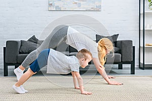 Side view of mother and son in adho mukha svanasana position
