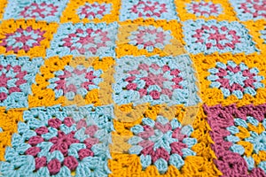Side view of multicolored crochet granny squares, seamed together in a blanket