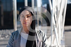 Side view of a muslim adult woman looking at camera in the park