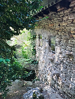 Side view of old stone country house and overgrown garden