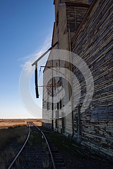 Side view of an old wooden grain elevator and track.