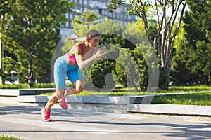 Side view. One young slim sportive caucasian woman running in the park or on city street.