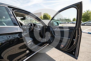 Side view of open car driver's door with dashboard