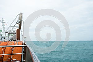 Side view of orange lifeboat steel fence and barrier to prevent