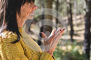 Side view of Padma mudra executed by a woman over nature background