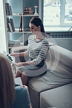 Side view of patient holding psychological test in arms in apartment