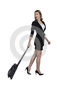 Side view photo of businesswoman in blace suit walking forward and pulling baggage