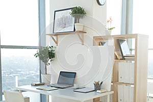 Side view picture of studio workplace with blank notebook, laptop. Designer comfortable work table, home office. photo