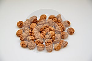 Side view of a pile of insulated tigernuts on a white background. The Spanish tigernut is called chufa