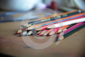 Side view of pile of sharpened colored pencils on a work surface.
