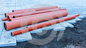 Side view of plastic orange pipes at a construction site