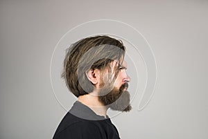 Side view portrait of bearded stylish young man looking away.