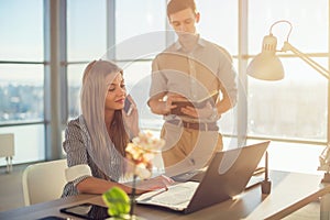 Side view portrait of colleagues in light spacious office busy during working day. Businesswoman planning schedule