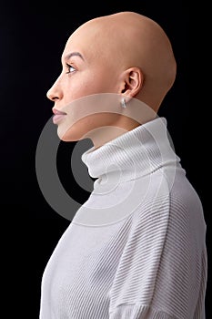 side view portrait of confident hairless young caucasian woman, with shaved head