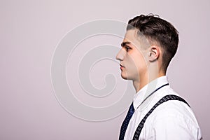 Side view portrait of confident man with beautiful hairstyle in white shirt looking on copy space isolated on white