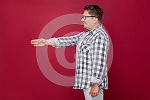 Side view portrait of happy excited middle aged business man in casual checkered shirt, eyeglasses standing, giving hand to