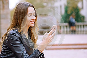 Side view portrait of happy women using smart phone outdoors